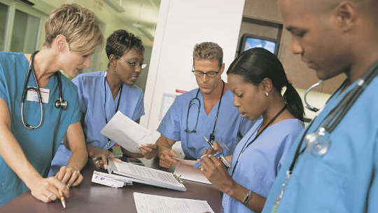 Why Quality Healthcare May Not Be As Difficult As It Seems group of healthcare professionals standing around a desk or table