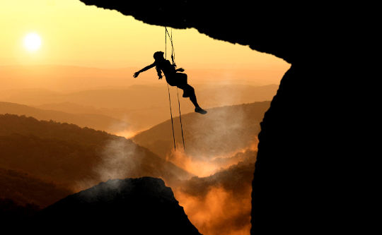 But We Are Afraid... a woman mountain climbing, hanging in mid-air