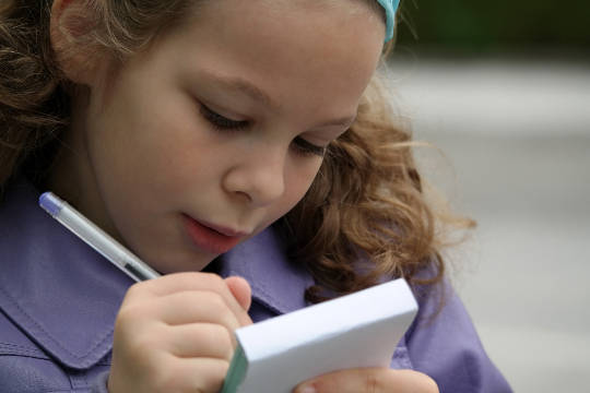 The Gift of a Friend a young girl intently writing on a pad of paper