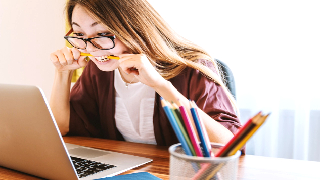 Feeling Stressed? Call for These 8 StressBusters young woman at her laptop biting down hard on a pencil