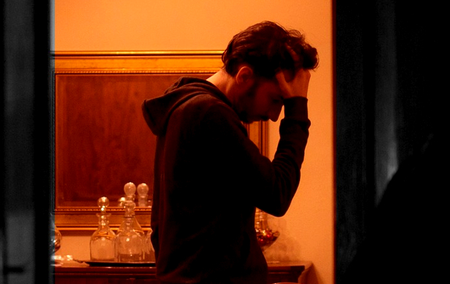 How to Prepare for Any Stressful Event a man standing in his house holding his hands over his face