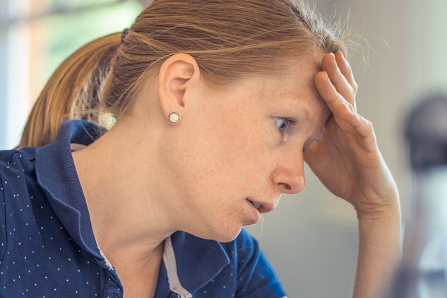 Rewiring Your Brain with Right or Wrong Mindfulness a woman in concentration resting her forehead on her hand