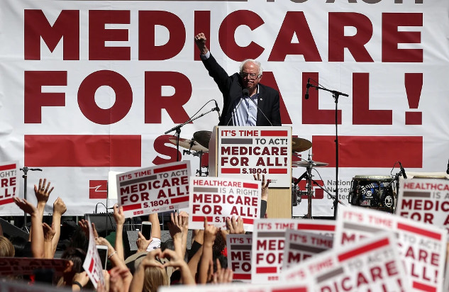 Trump’s Promises vs. Reality: Medicare and Social Security at Risk A rally with signs reading “Medicare for all,” showcasing grassroots advocacy.